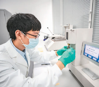 在重庆三峡文物科技保护基地内,“文物医生”运用各种“诊疗”设备对手里的文物进行精准治疗,让其焕发出新的活力。 图为2022年,“文物医生”利用耐折度仪对纸张的耐折度进行测试。 新华社记者 黄 伟摄