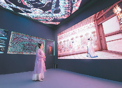 第十九届中国(深圳)国际文化产业博览交易会设立了“数字中国——AI时代的文化创新”主题展区。一批大数据、人工智能等技术应用文化企业参展。数字化助力中华传统文化“活”起来,也为现场观众带来了新鲜的观展体验。 图为一名身着传统服饰的观众在文博会甘肃展台观看数字敦煌展览。 新华社记者 梁 旭摄